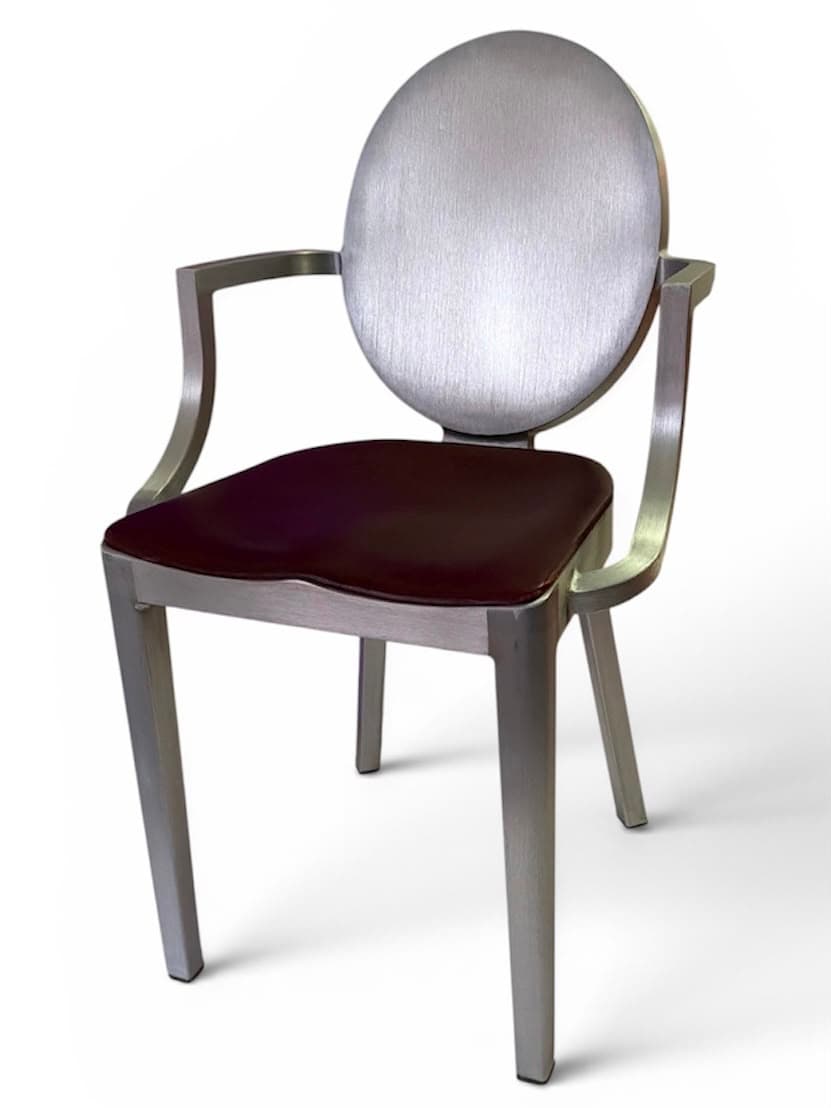 Brushed aluminium armchair with oval back and oxblood leather seat, three-quarter view